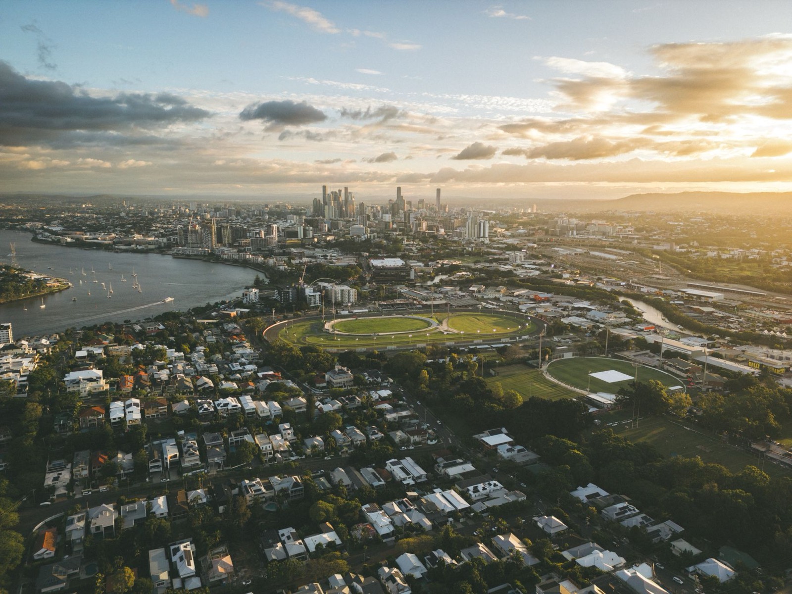 Aerial view of Brisbane suburbs and city skyline at sunset