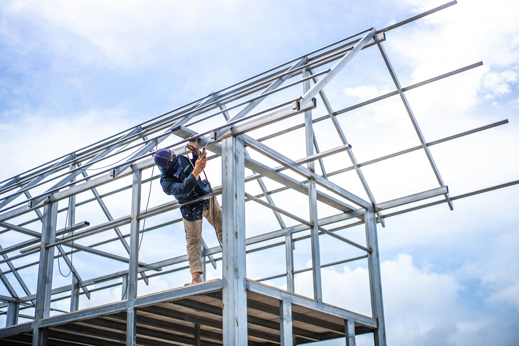Steel frame home under construction against a blue sky